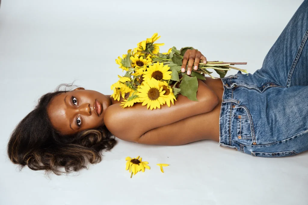 Studio boudoir photography of Black woman with sunflowers capturing intimate and elegant portrait in Denver Colorado